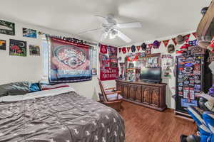 Bedroom featuring ceiling fan and dark wood-type flooring