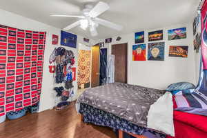 Bedroom with hardwood / wood-style floors and ceiling fan