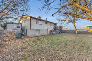 Back of property featuring a yard and a wooden deck