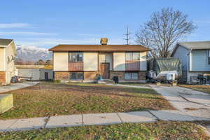 Bi-level home featuring a mountain view and a front yard