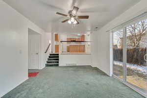 Unfurnished living room with carpet flooring and ceiling fan