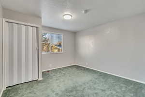 Carpeted empty room with a textured ceiling