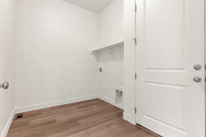 Clothes washing area featuring washer hookup and light hardwood / wood-style floors