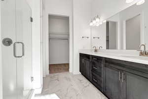 Bathroom with vanity and a shower with door