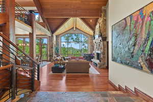 Living room featuring beam ceiling, wooden ceiling, a fireplace, and dark wood-type flooring