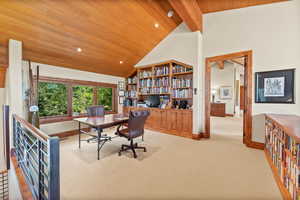 Home office featuring beam ceiling, light carpet, high vaulted ceiling, and wood ceiling