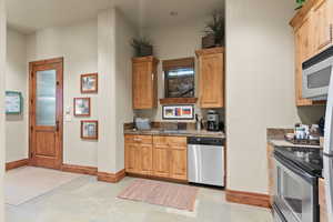 Kitchen featuring sink, light tile patterned floors, and appliances with stainless steel finishes