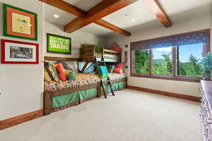 Bedroom featuring beam ceiling and carpet