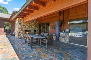 View of patio / terrace with an outdoor stone fireplace, area for grilling, and grilling area