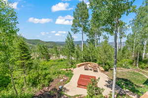 View of community featuring a mountain view, a patio, and an outdoor fire pit