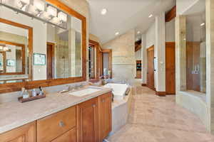 Bathroom featuring vanity, plus walk in shower, and lofted ceiling