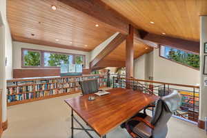 Carpeted office with lofted ceiling with beams and wood ceiling