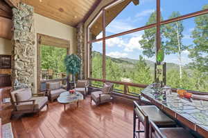 Unfurnished sunroom with a mountain view, plenty of natural light, and vaulted ceiling