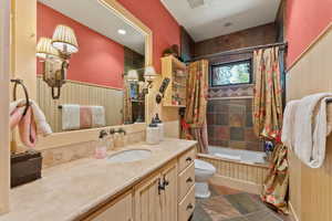 Full bathroom featuring tile patterned floors, vanity, toilet, and shower / bath combo with shower curtain