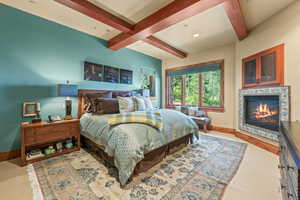 Bedroom with beam ceiling and light hardwood / wood-style flooring