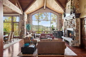 Living room featuring a mountain view, dark hardwood / wood-style flooring, a fireplace, and high vaulted ceiling