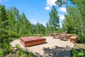 View of patio with a mountain view and a covered hot tub