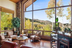 Sunroom / solarium featuring a mountain view, plenty of natural light, and lofted ceiling