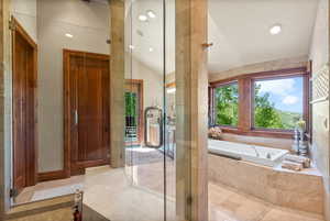 Bathroom featuring tile patterned floors, independent shower and bath, and lofted ceiling