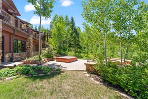 View of yard featuring a patio area, a balcony, and a hot tub