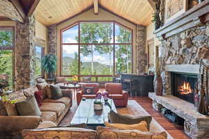 Living room with a fireplace, a mountain view, dark hardwood / wood-style flooring, and high vaulted ceiling