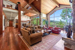 Living room with beam ceiling, a mountain view, high vaulted ceiling, and hardwood / wood-style flooring