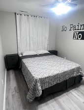 Bedroom with hardwood / wood-style floors and ceiling fan