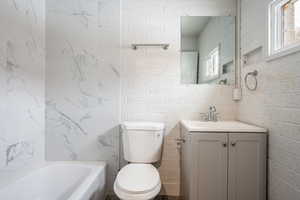 Bathroom with a wealth of natural light, vanity, and toilet