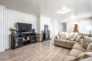 Living room with a textured ceiling and light wood-type flooring