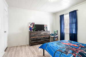 Bedroom with light wood-type flooring and ornamental molding