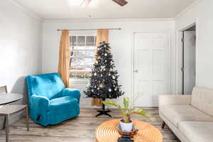 Sitting room featuring hardwood / wood-style flooring, ceiling fan, and ornamental molding