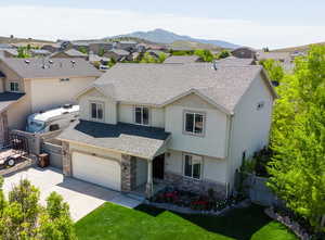 View of front of home featuring a mountain view, a garage, and a front yard