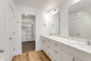 Bathroom featuring vanity, wood-type flooring, and a textured ceiling