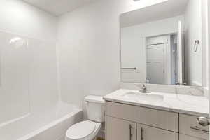 Full bathroom with vanity, shower / bathtub combination, and toilet