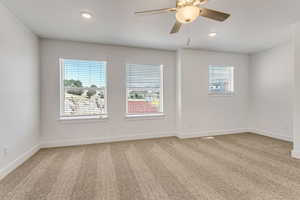 Unfurnished room with ceiling fan, a healthy amount of sunlight, and carpet floors