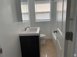 Bathroom featuring tile patterned flooring, vanity, and toilet