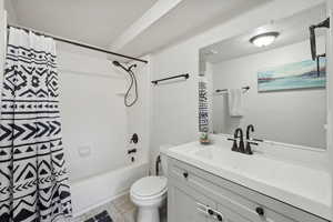 Full bathroom with toilet, shower / bath combination with curtain, vanity, and tile patterned floors