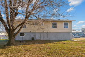 View of side of property with a lawn and central AC