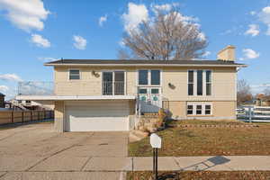 Bi-level home with a front lawn and a garage