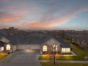 View of front of home featuring central AC, a garage, and a lawn