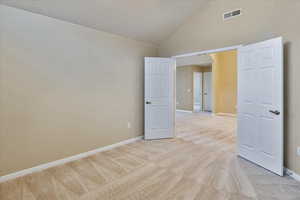 Carpeted empty room with high vaulted ceiling and a textured ceiling