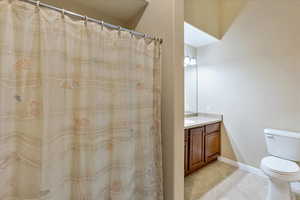 Bathroom with toilet, vanity, and tile patterned floors