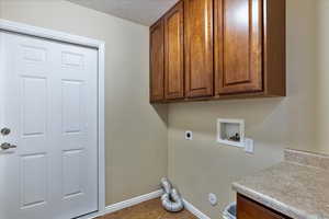 Washroom featuring cabinets, hardwood / wood-style flooring, washer hookup, a textured ceiling, and hookup for an electric dryer