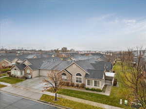 View of front of home with a front lawn, central AC unit, and a garage