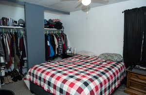 Carpeted bedroom featuring ceiling fan and a closet