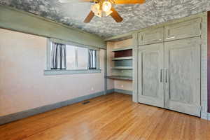 Unfurnished bedroom with ceiling fan and light hardwood / wood-style floors