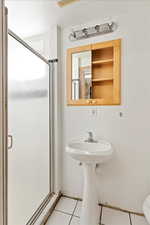 Bathroom with tile patterned flooring, toilet, a textured ceiling, and an enclosed shower