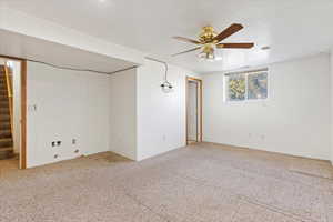 Carpeted spare room featuring ceiling fan