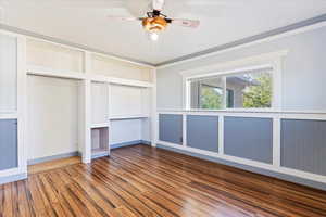 Unfurnished bedroom featuring hardwood / wood-style flooring, ceiling fan, and ornamental molding