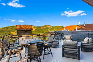 View of patio with outdoor lounge area, a mountain view, and a balcony